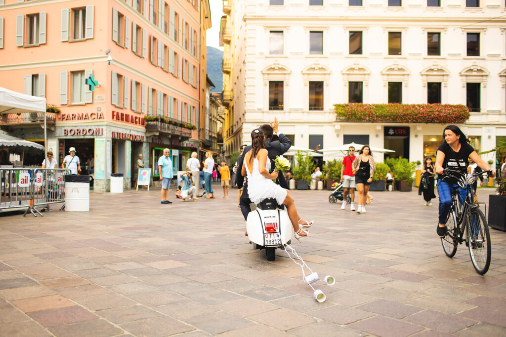 Reportage fotografico arrivo sposi in vespa in piazza a Lugano